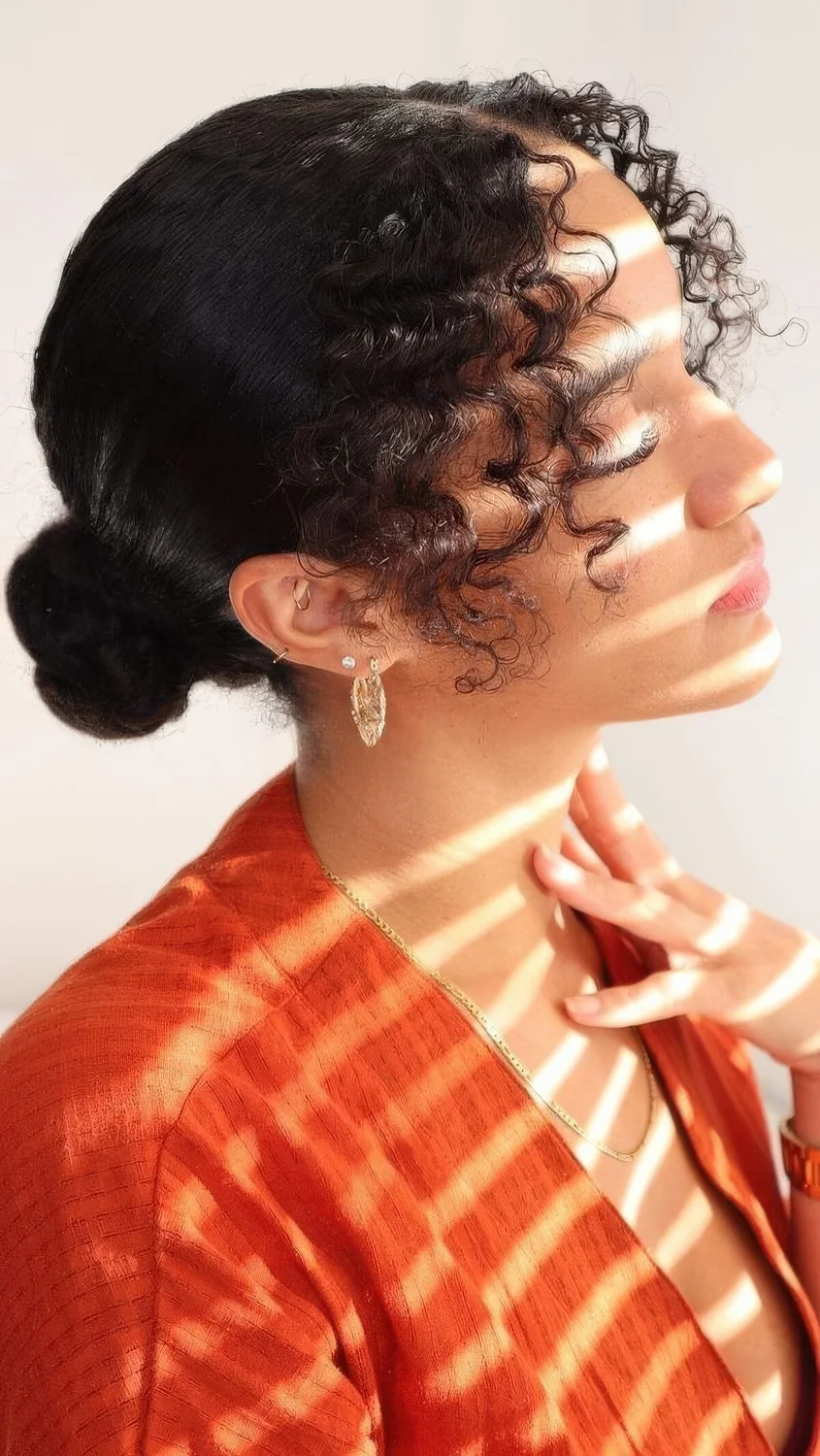 Sleek and elegant low bun on straightened hair and curls framing the face are a perfect and chic combo.
