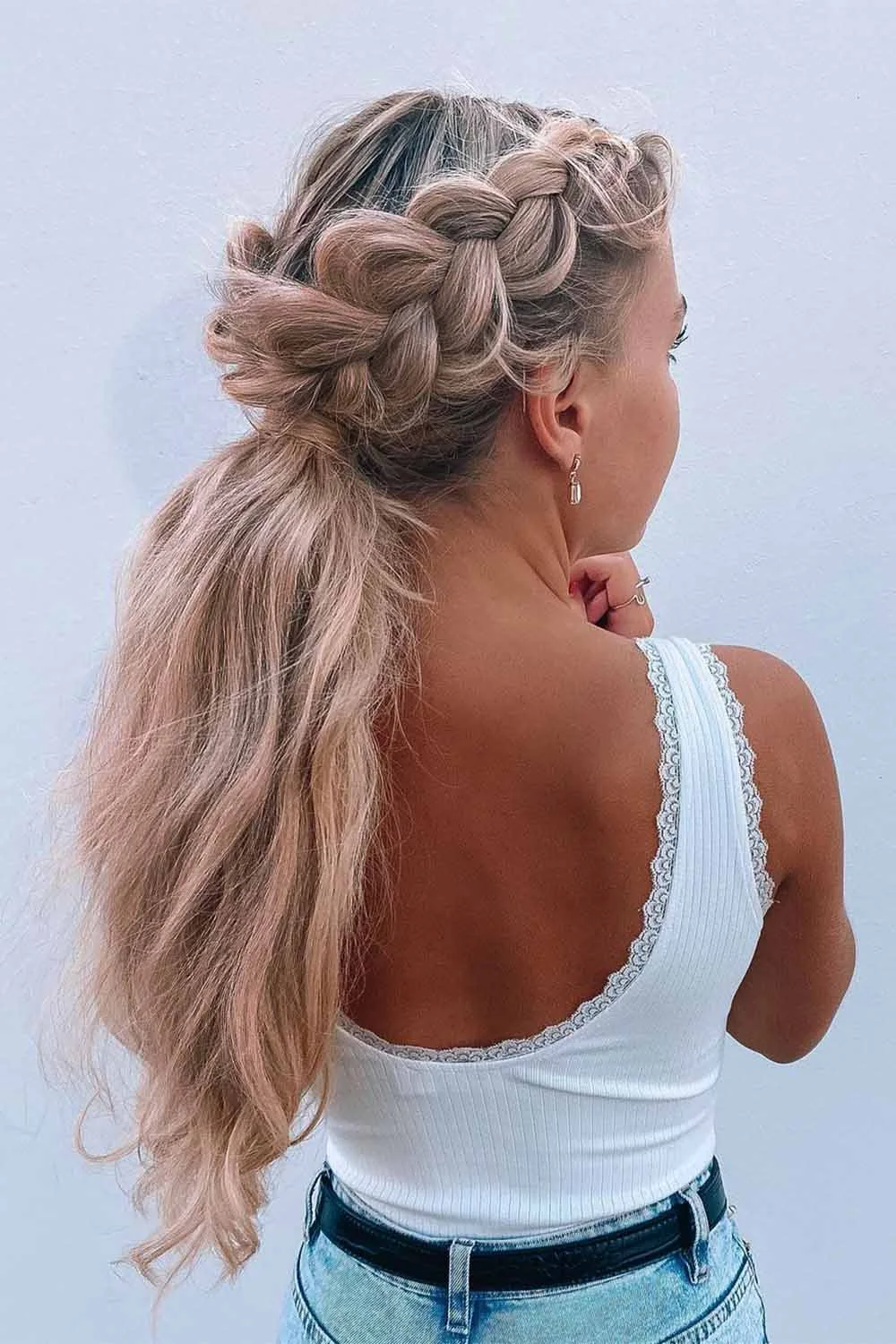Blonde hair with a broad raised side braid leading into a loose ponytail