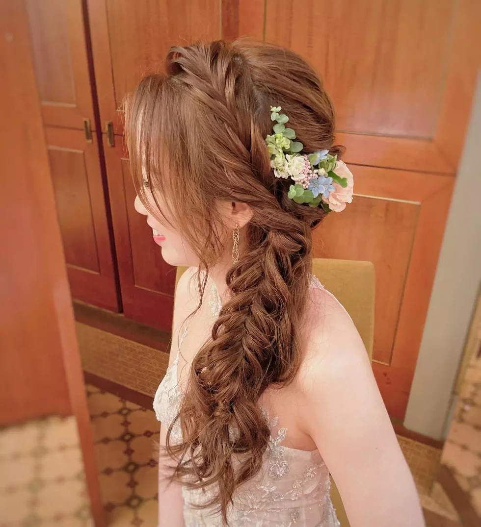 Side braid with a white flower clip and loose waves