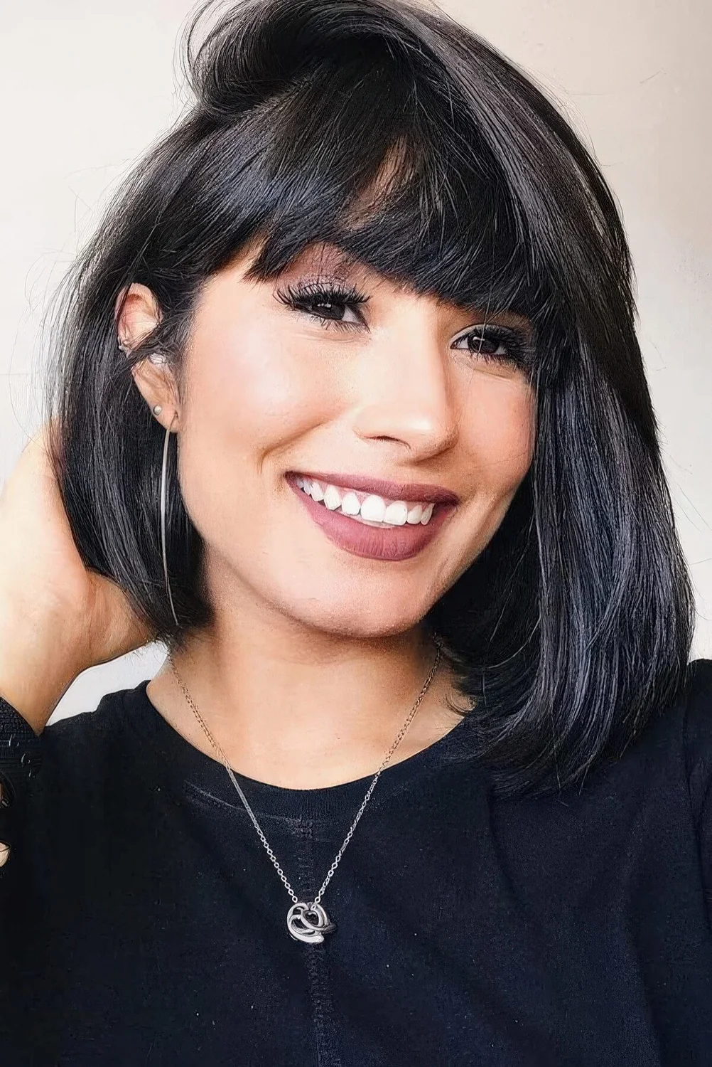 Photo showing asymmetrical bob with bangs, with the hairstyle clearly visible.
