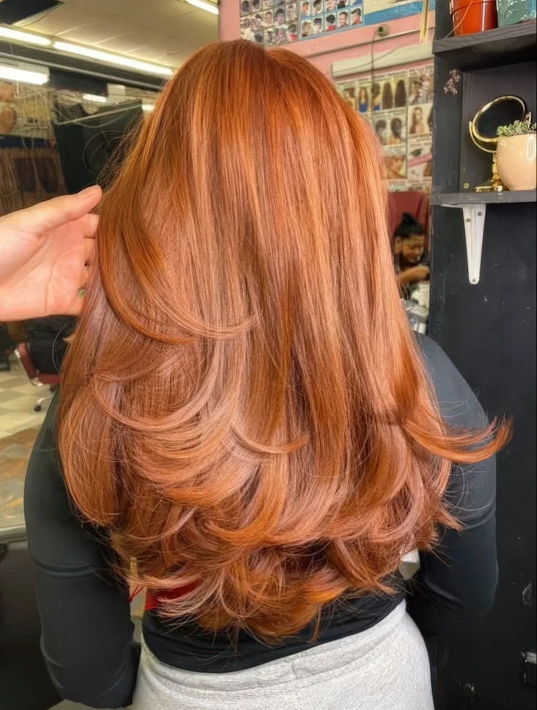 Copper long butterfly haircut with some highlights and curled ends, a lot of volume.