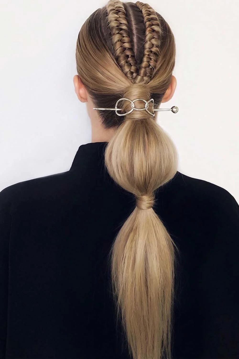 Back view of blonde crown braids leading into a bubble ponytail with rings at the upper base