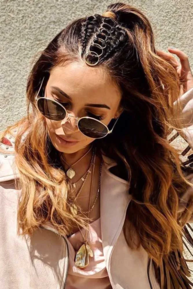 Front-side view of wavy brunette hair with a small ringed braid leading toward a high gathered top