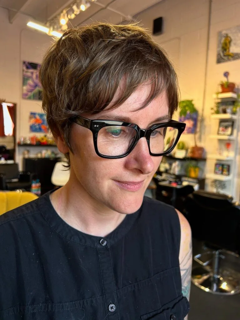 brunette pixie with glasses showing brunette short hair with straight texture for thin fine hair