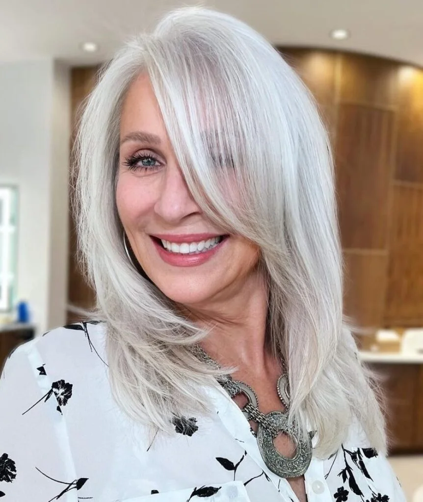 Long Silver Layers haircut for women over 50 with gray straight hair and a face-flattering shape