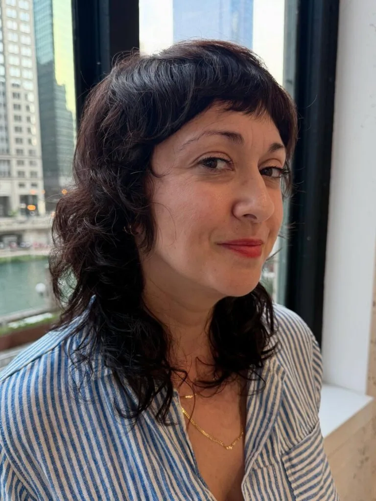 Curly medium shag with short curly bangs for a woman over 40