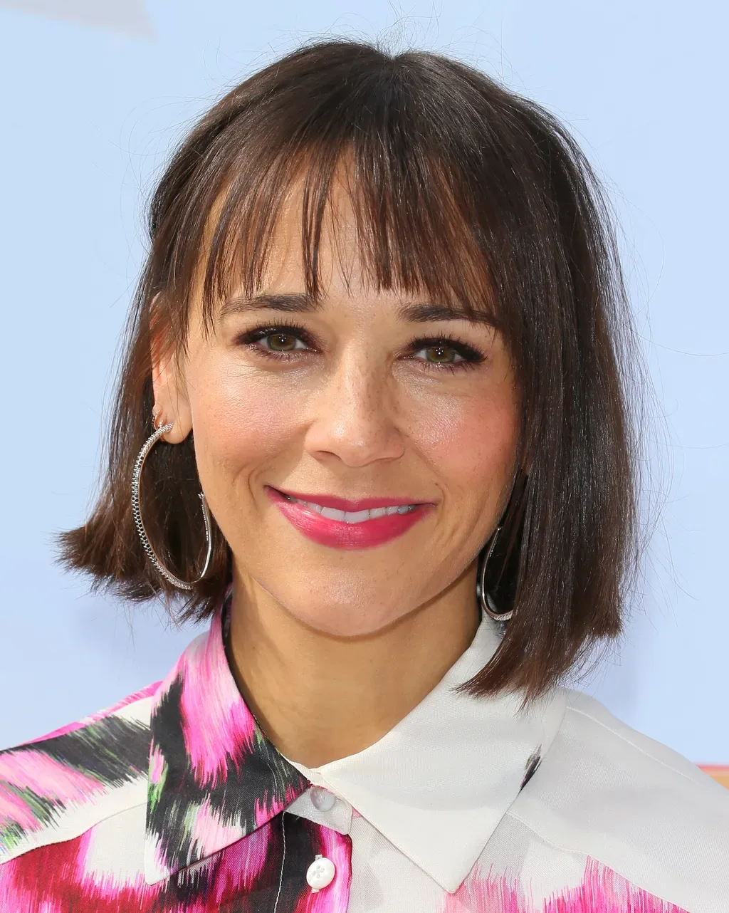 Polished brunette bob with wispy bangs and a smooth chin length shape