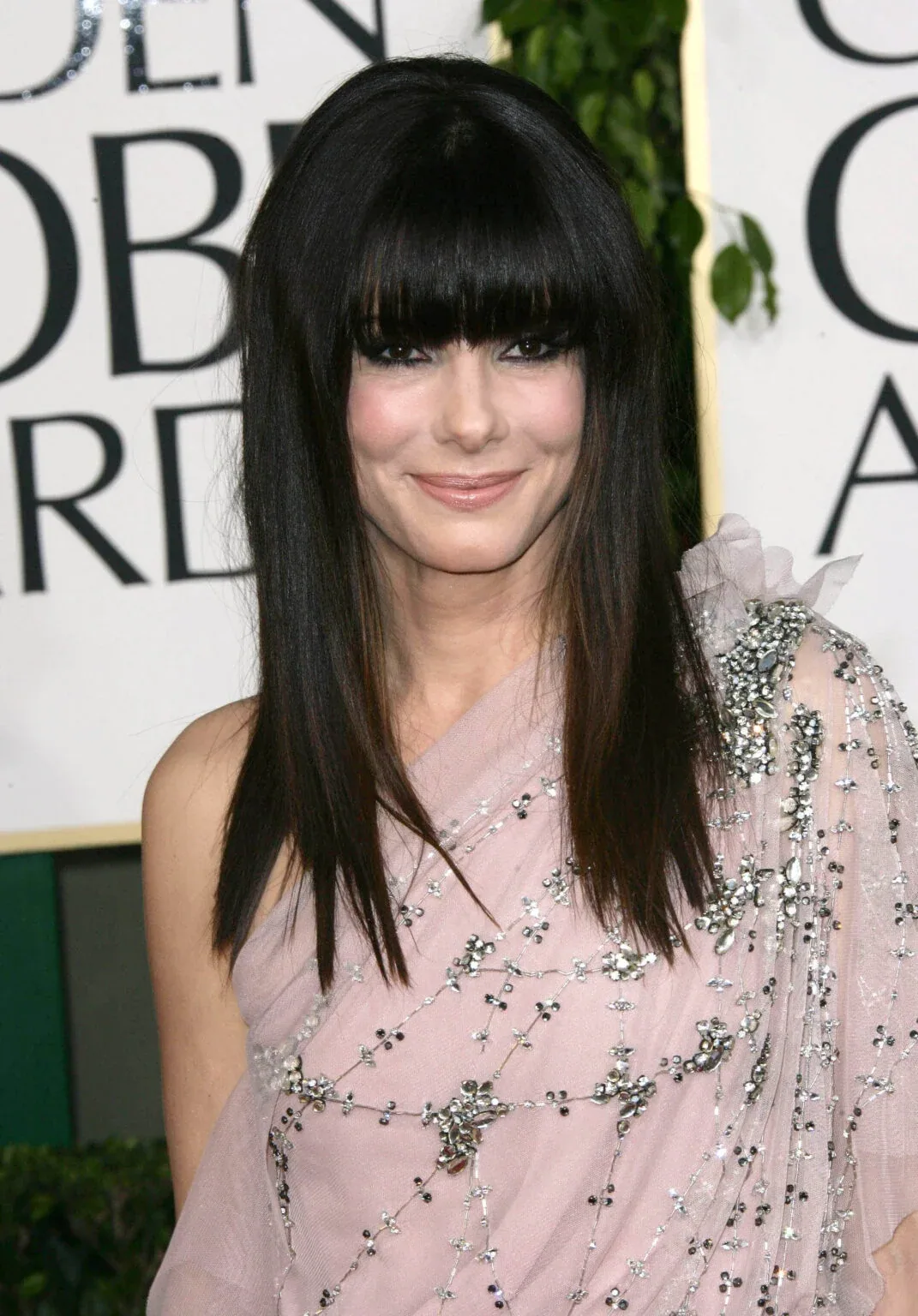 Long straight black hair with full blunt bangs for a polished look