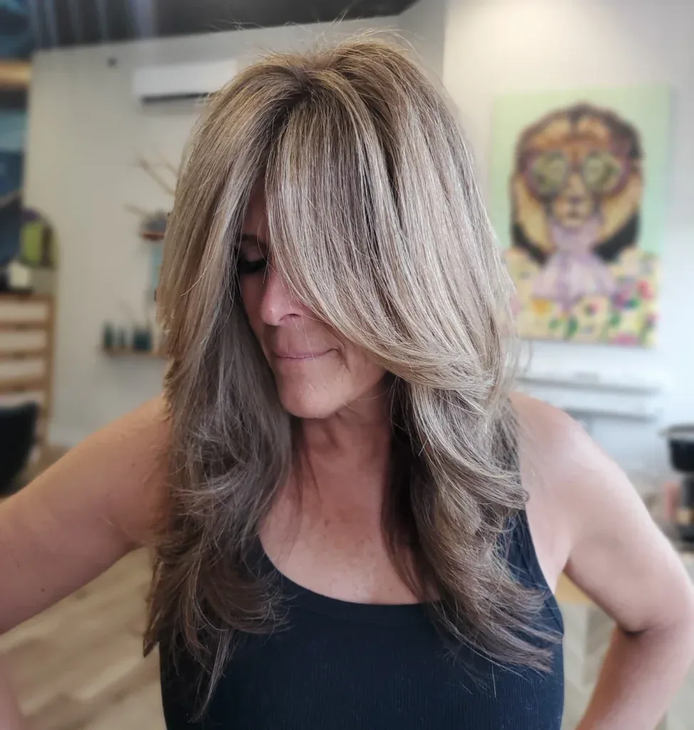 Long blonde layered hair with curtain fringe and soft waves