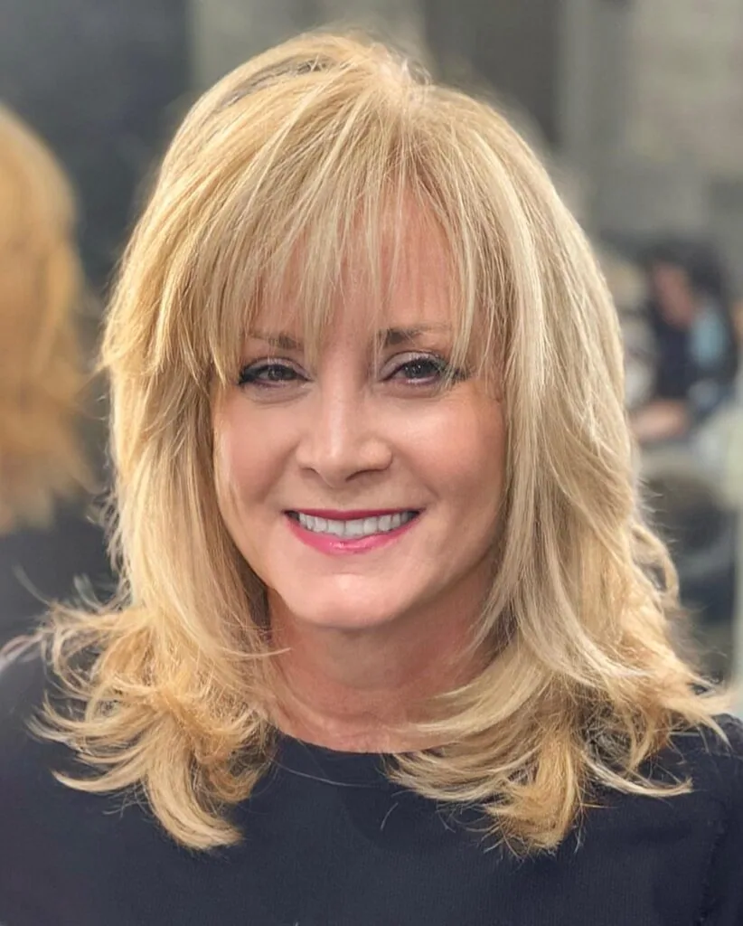 Blonde shoulder length layers with feathered bangs and soft volume