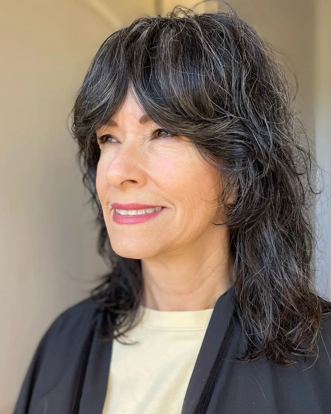 Medium wavy shag with curtain bangs and gray-black layered texture