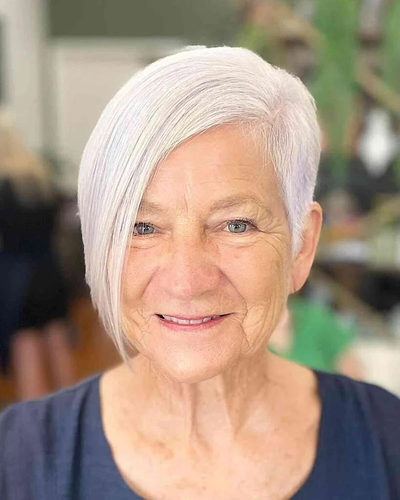 A soft gray chin bob with light volume, clean sides, and a simple rounded edge. This hairstyle is shown as inspiration for women over 60 with thin hair.