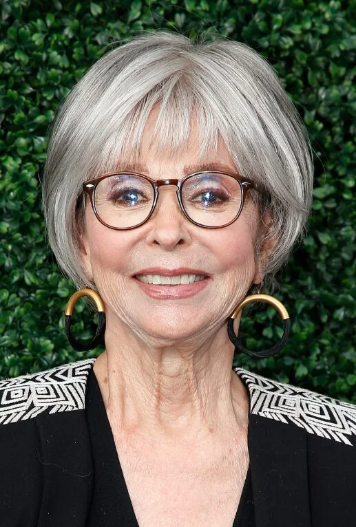 Silver bob with wispy bangs and glasses on an older woman