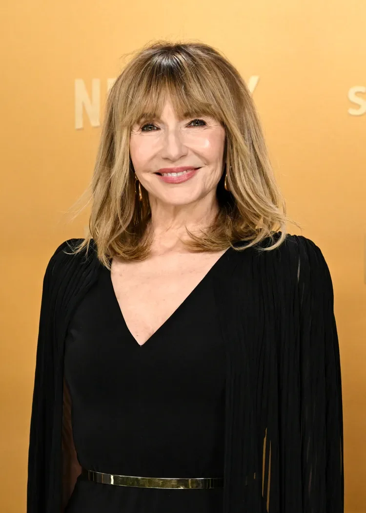 Long blonde layers with soft bangs on an older woman