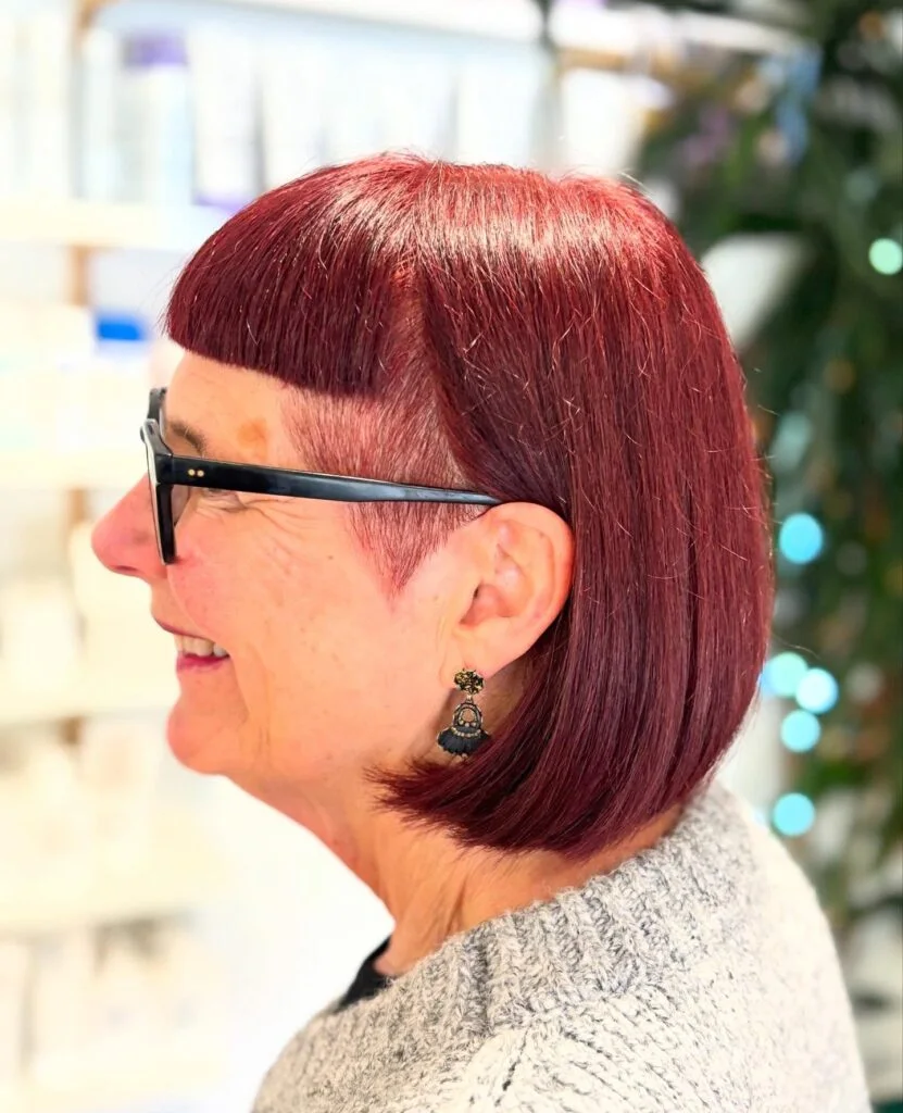 Red bob with blunt bangs and glasses from the side