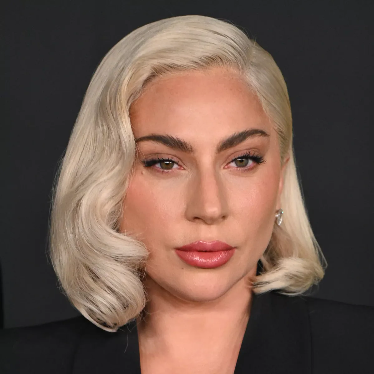 chin wavy blonde bob shown as a hollywood waves idea, featuring glossy finish, shown in blonde wavy bob with glossy finish
