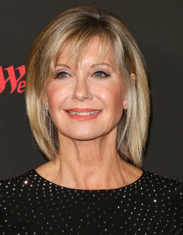 Classic blonde layered bob with feathered bangs on a woman over 60
