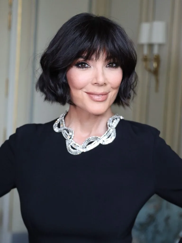 Older woman with a black wavy bob and soft bangs