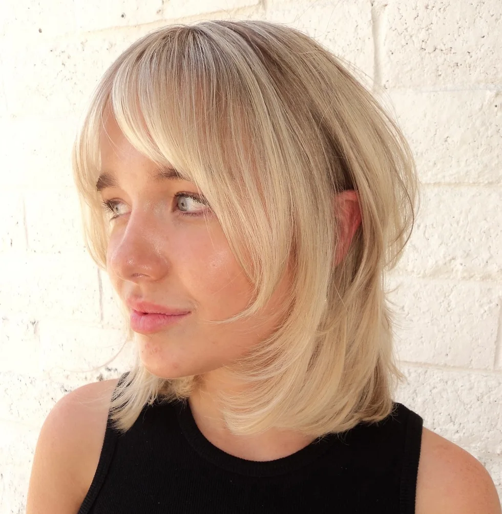 Soft blonde bob with airy curtain bangs and rounded face-framing layers