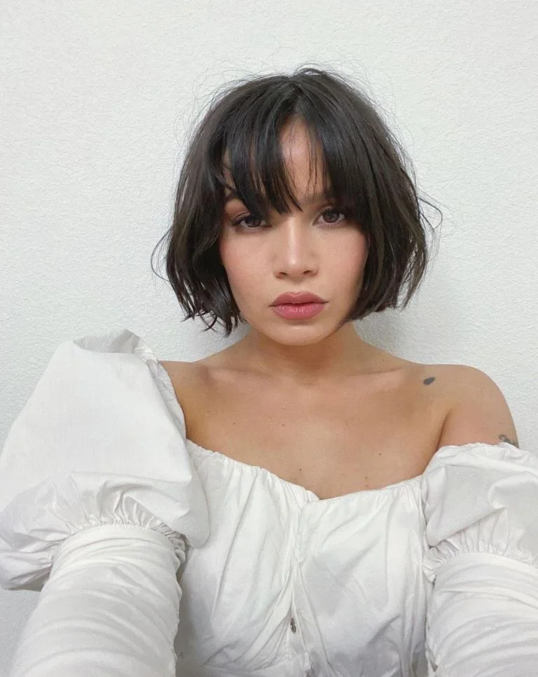 Black wavy layered bob with curtain bangs and soft chin-length movement