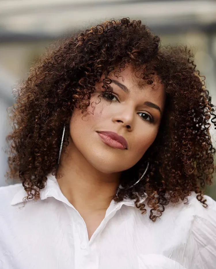 Curly layered bob with curtain bangs and rounded face-framing volume