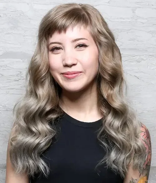 gray wavy layers with wispy bangs showing gray long hair with wispy bangs and wavy texture
