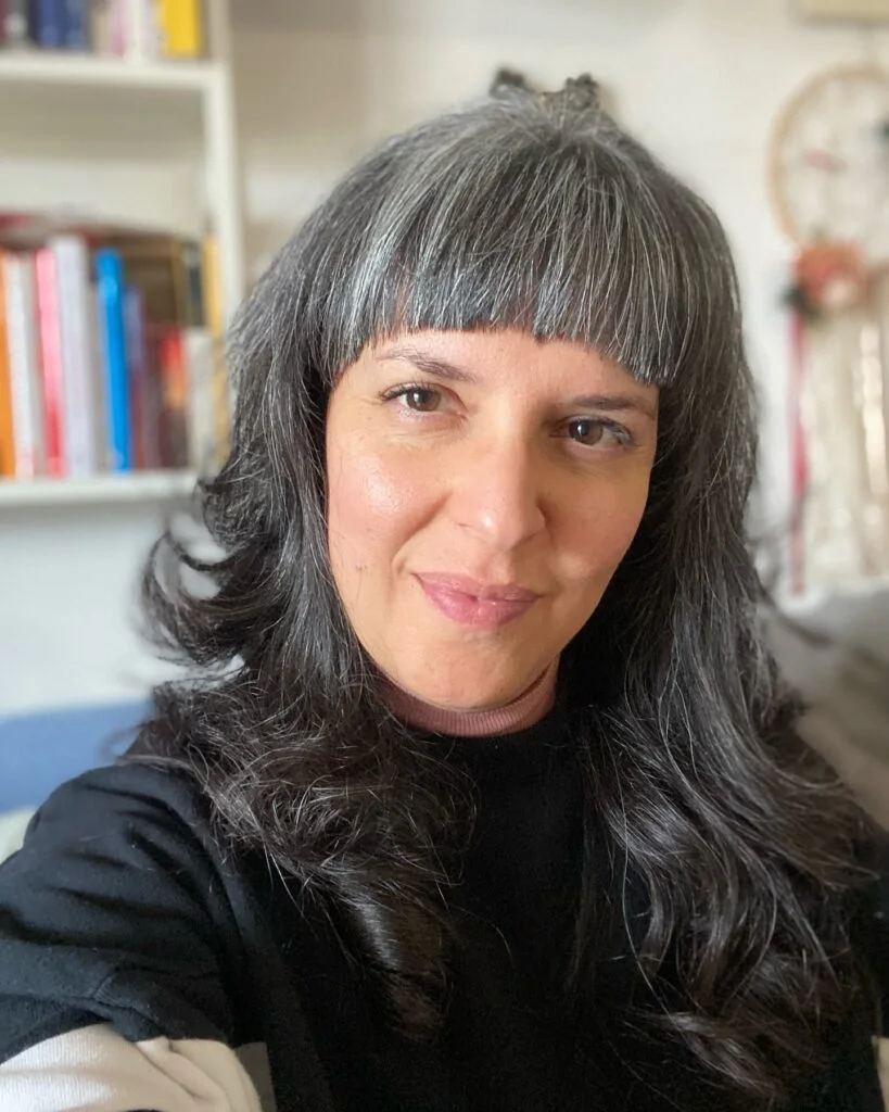 gray layers with blunt bangs showing gray long hair with blunt bangs and wavy texture