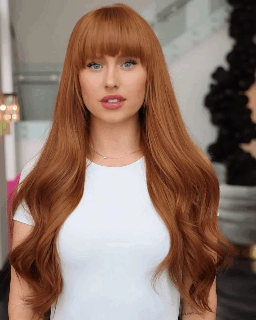 copper layers with full bangs showing red long hair with full bangs and wavy texture