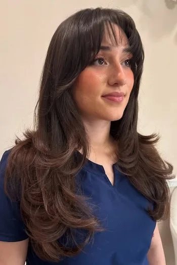 brunette curtain bang layers showing brunette long hair with curtain bangs and wavy texture