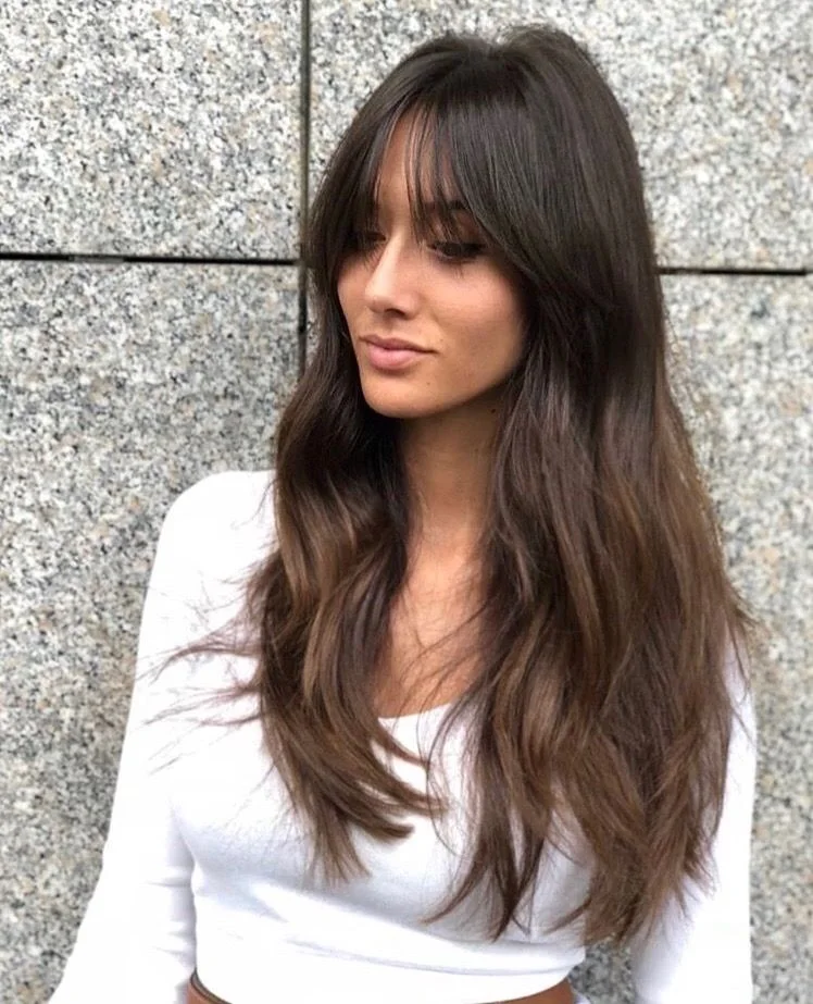 long brunette curtain layers showing brunette long hair with curtain bangs and wavy texture