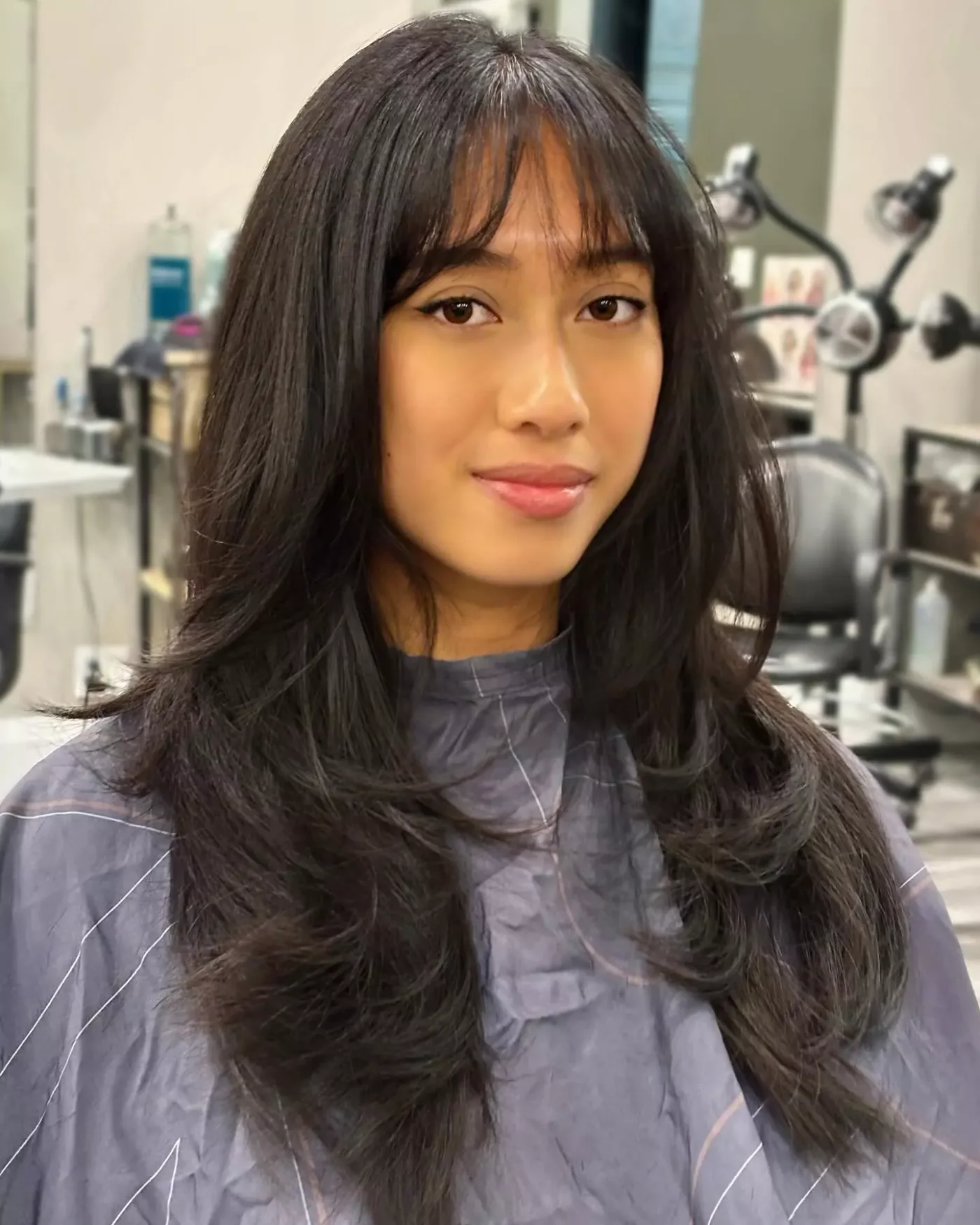 sleek black layers with full bangs showing black long hair with full bangs and straight texture
