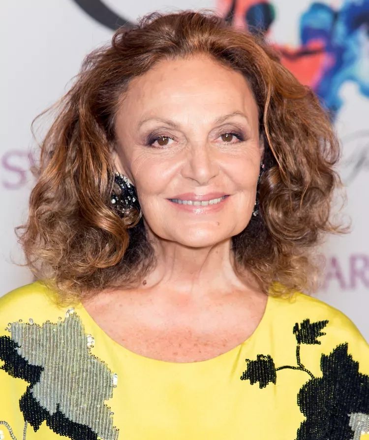 Older woman with auburn curly layered hair and soft rounded volume