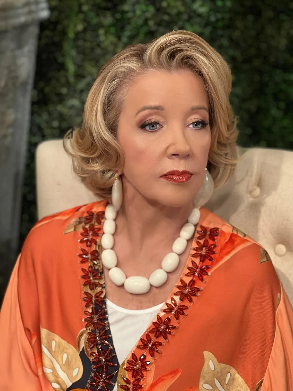 Older woman with golden medium wavy layers and soft volume around the face