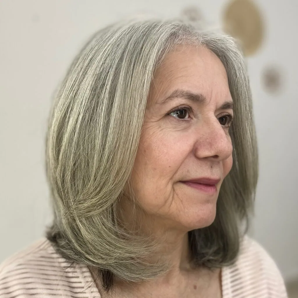 Older woman with long straight silver layers and a soft side profile