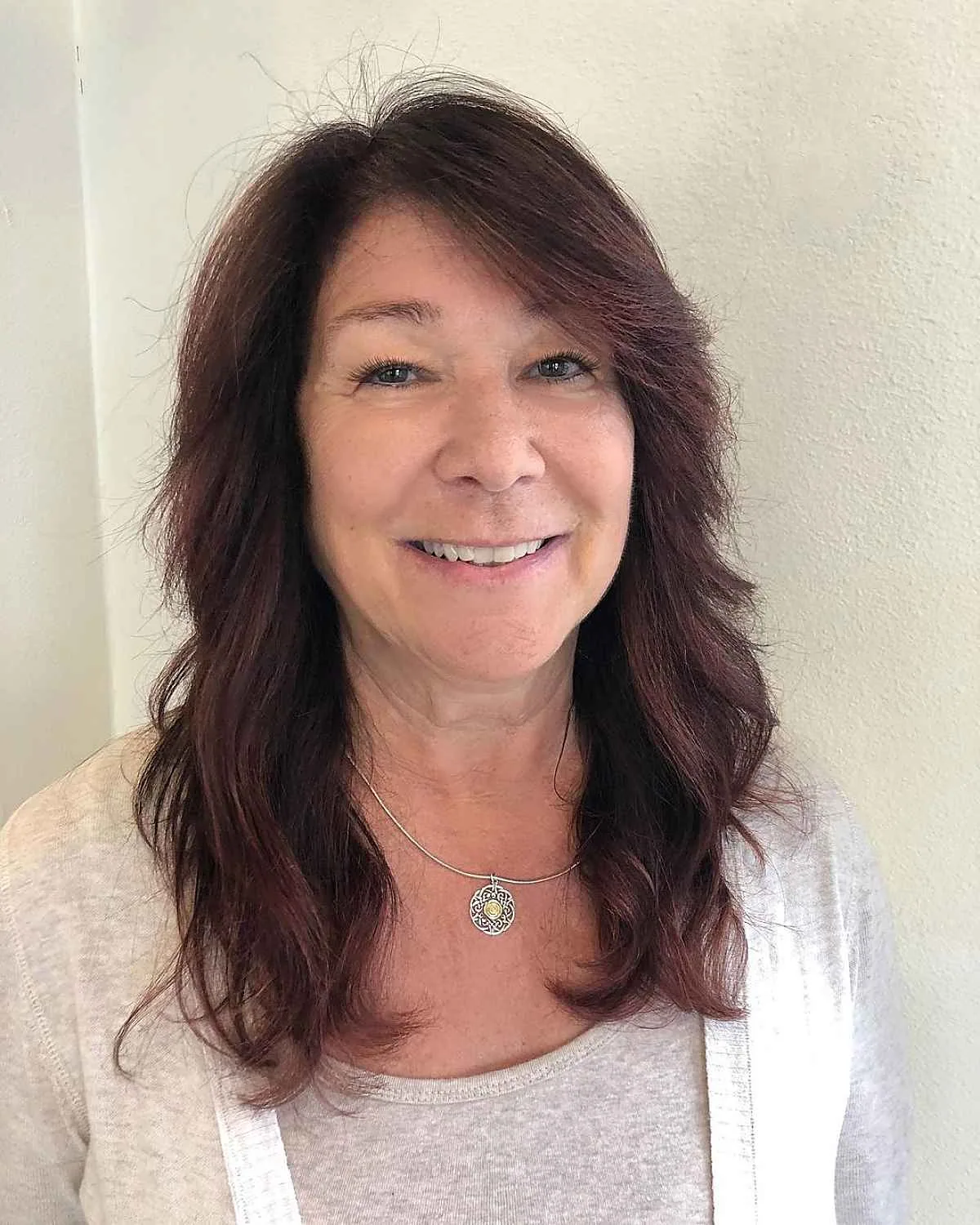 Mature woman with brunette shoulder-length layers and loose wavy texture