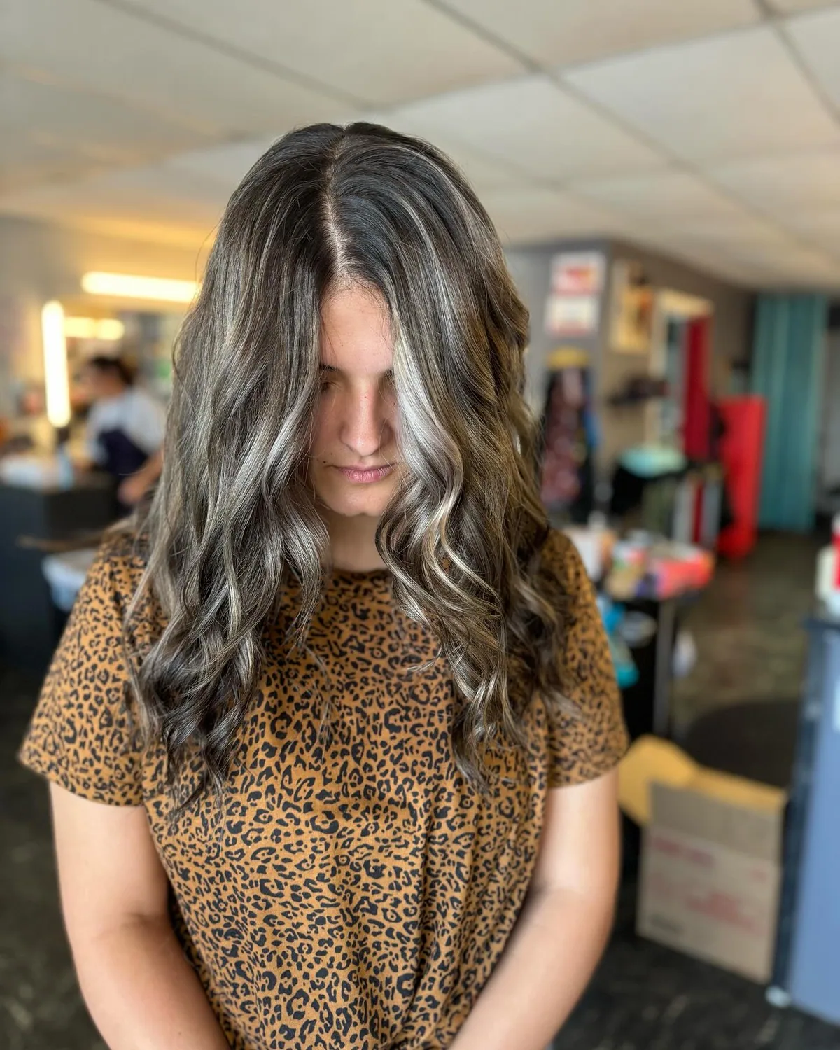 Older woman with long silver wavy layers and a soft center part