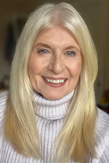 Older woman with long white straight hair and subtle face-framing layers