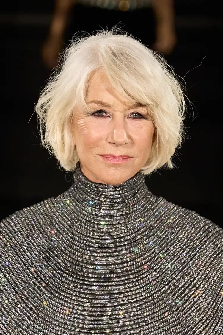 Older woman with a blonde feathered pixie, side bangs, and short layered volume