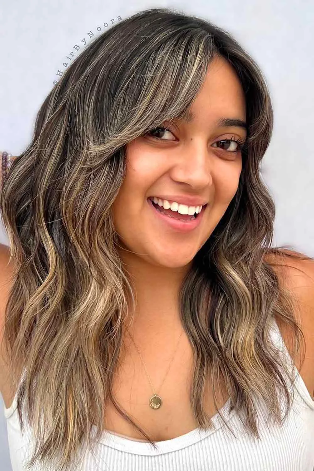 Front view of brown waves with lighter beige ribbons beside a side-swept fringe