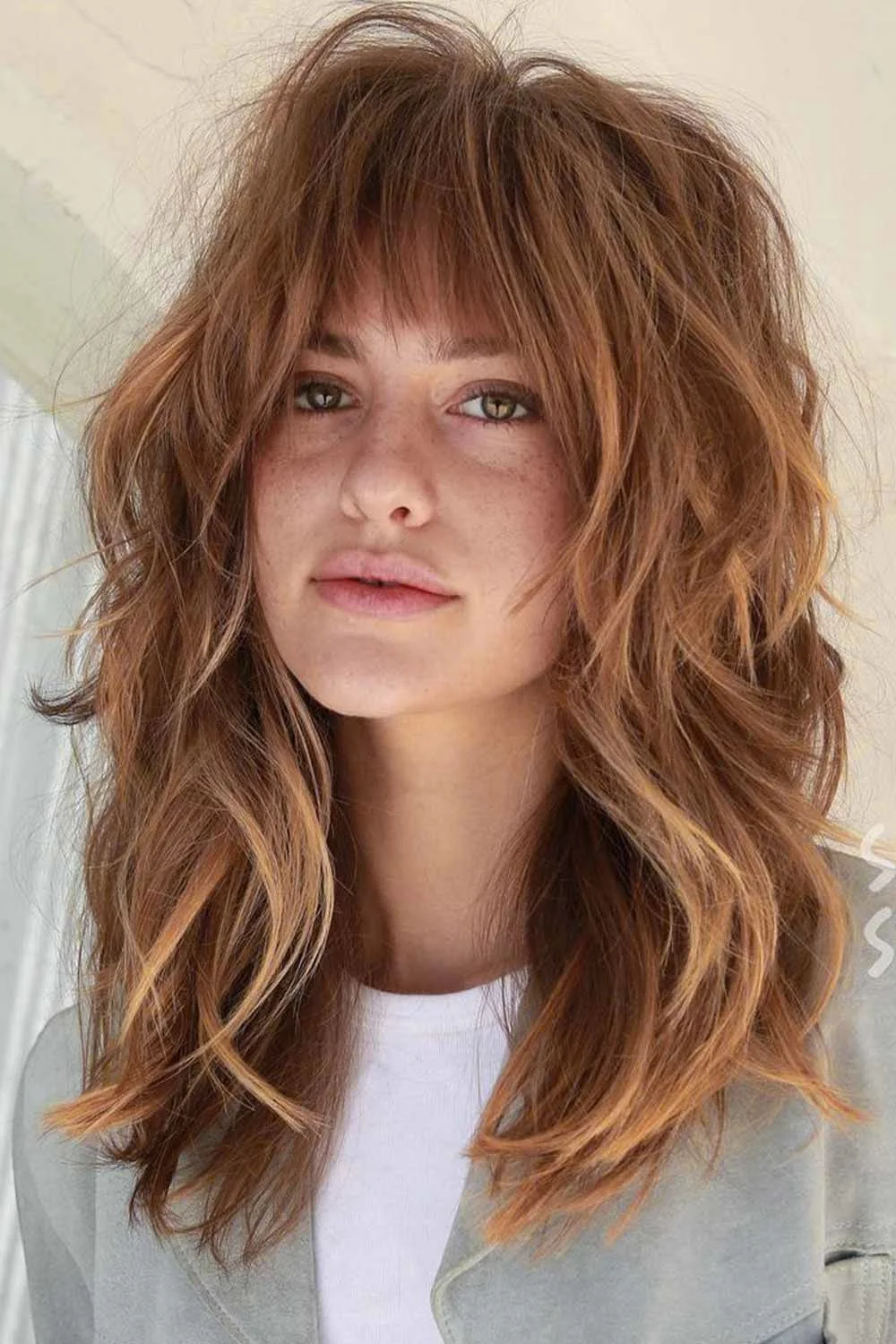 Front view of honey brown shaggy layers and a separated eyebrow-length fringe