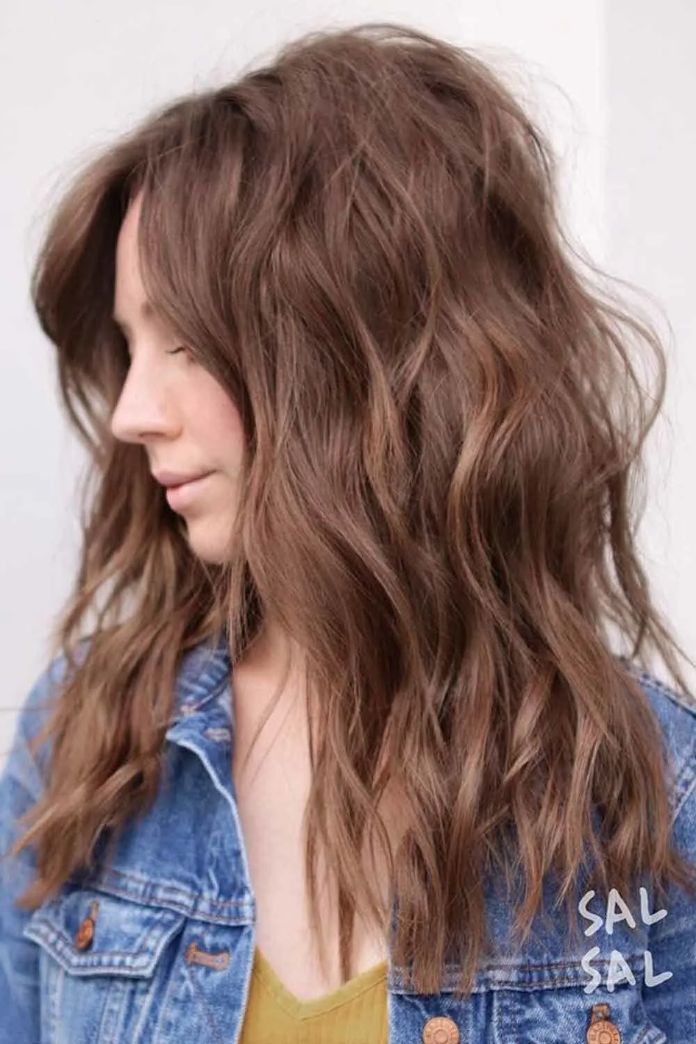 Side view of shoulder-length soft brown shaggy waves with a side opening