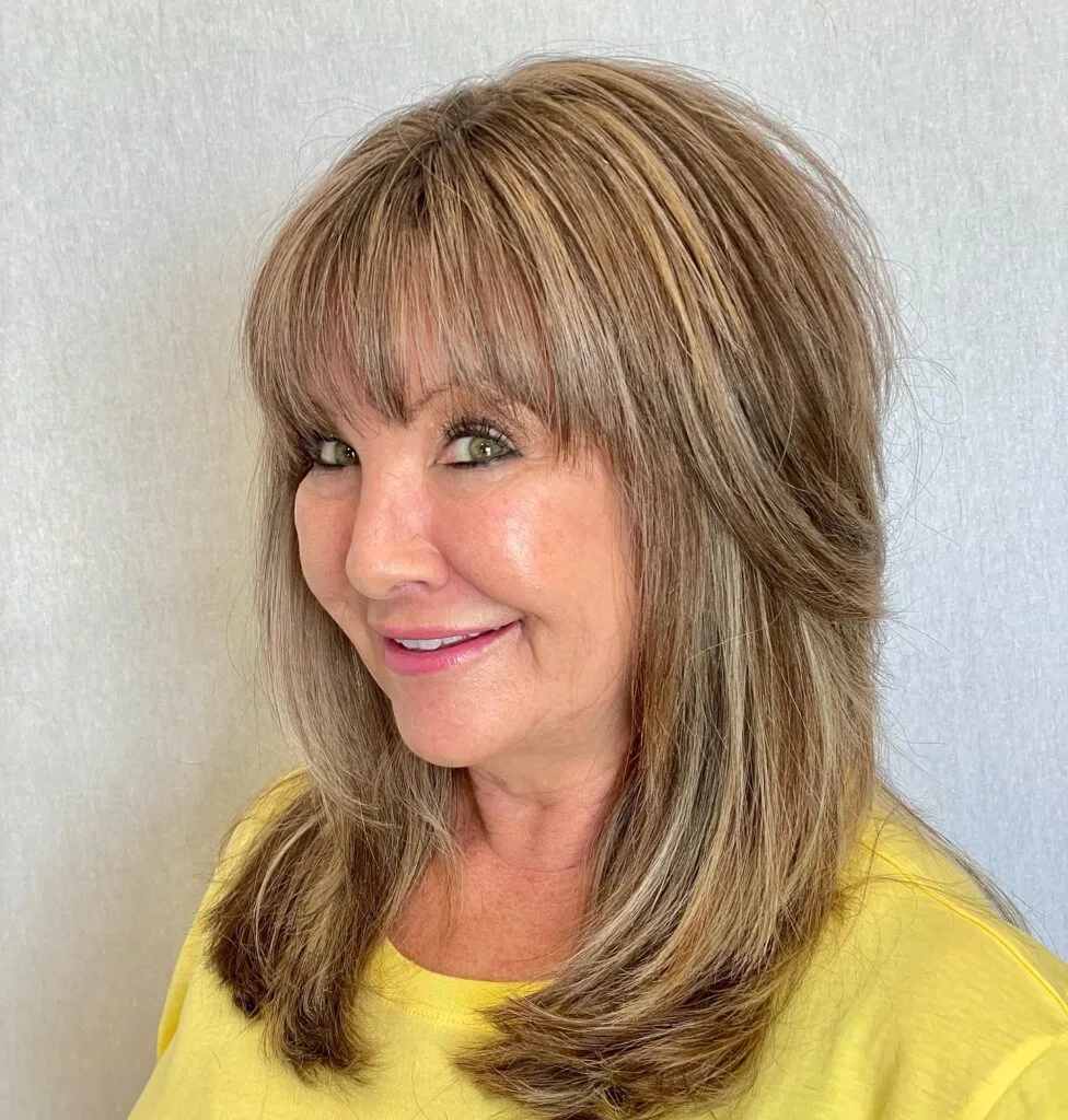 Layered honey blonde lob with bangs and soft volume for thin hair