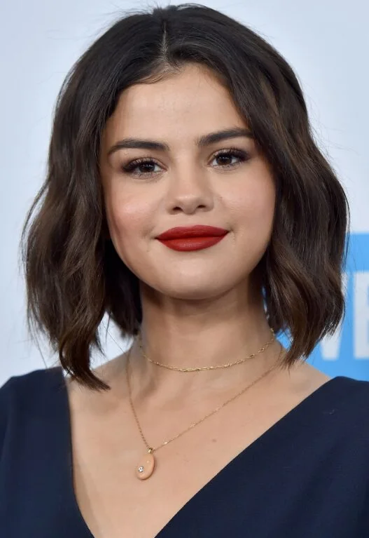 Glossy brunette wavy lob haircut with soft middle part for thin hair
