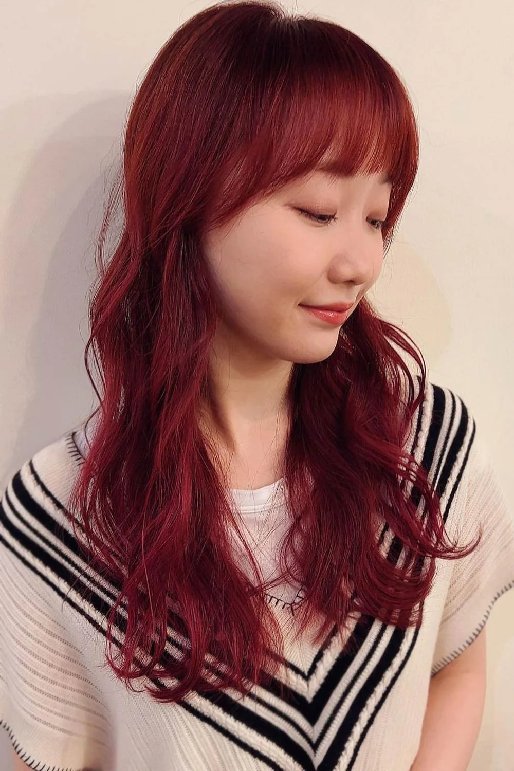 Side-front view of long red waves with a softly rounded full fringe