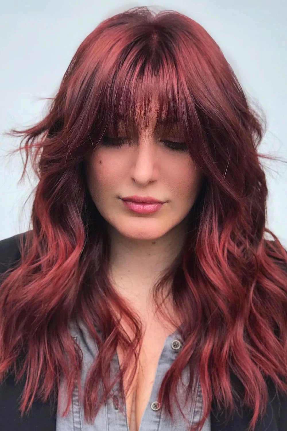 Front view of long burgundy shaggy layers with separated eyebrow-length bangs