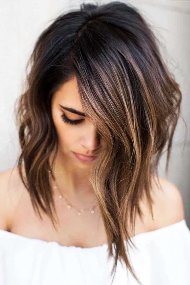 Front view of medium brown waves with dark roots and longer pointed front ends