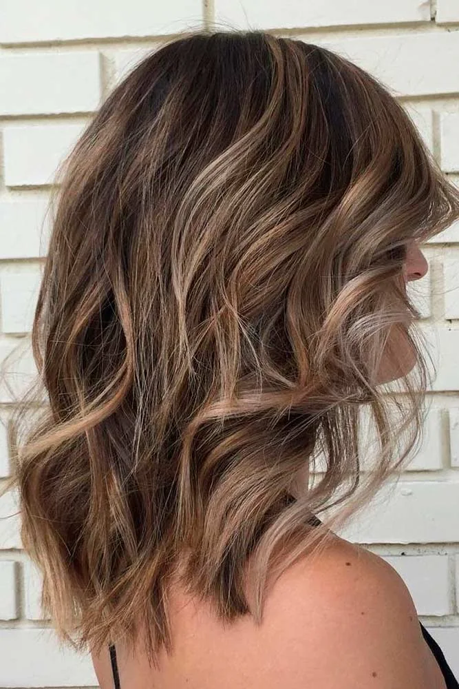 Side-back view of a medium brown bob with loose waves and lighter ribbons