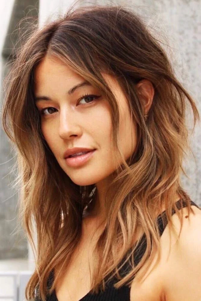 Front-side view of medium warm brown waves with soft long face-framing pieces