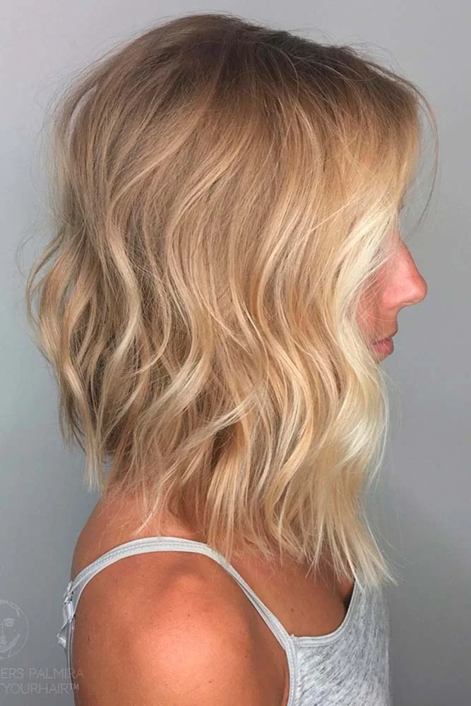 Side view of a blonde lob with loose bends and a relatively flat lower edge