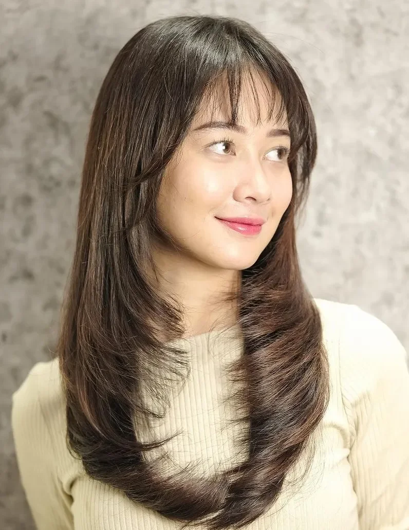 Wispy medium length haircut with light bangs and soft layers for thin fine hair